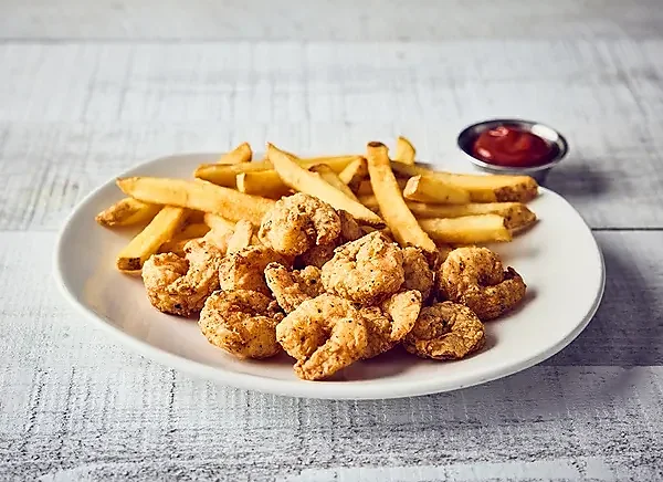 Plate of seasoned fried shrimp with french fries and ketchup
