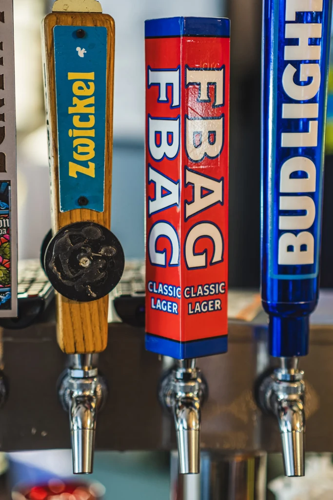 Close-up of four beer tap handles, including Zwickel, FBAG, and Budlight.