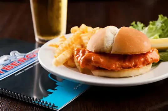 Buffalo chicken sandwich, crinkle-cut fries, lettuce, and pickle spear.