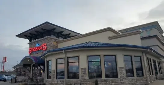 Modern Syberg's restaurant building with red neon sign and blue fish logo.
