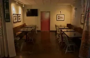 Casual restaurant interior with tables, a booth, a red door, and number one.