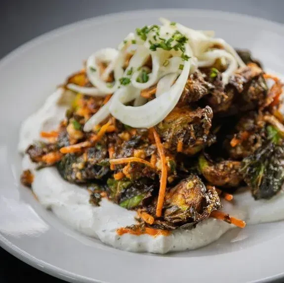 Roasted Brussels sprouts, shredded carrots, creamy sauce, and fresh herbs.