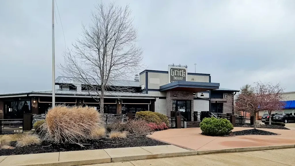Brick House Tavern exterior, multi-level building, sparse landscaping, overcast sky.