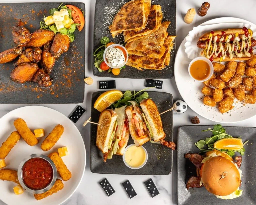 An overhead shot of six diverse dishes and game pieces.
