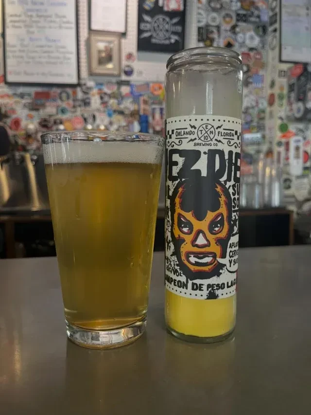 Light beer beside an EZ Diez lucha libre mask candle.