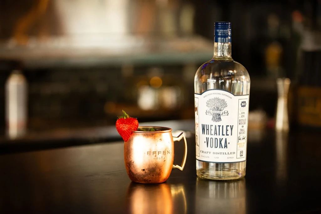 Tarnished copper Moscow Mule mug with strawberry, Wheatley Vodka bottle.