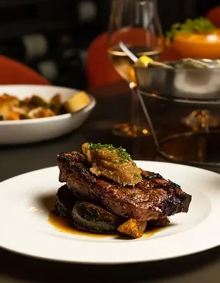 Grilled steak with relish, green herbs, and rich brown sauce.
