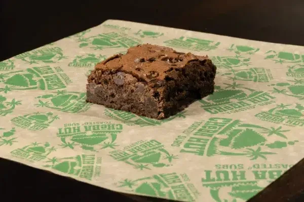 Dark chocolate chip brownie on Cheba Hut patterned paper.