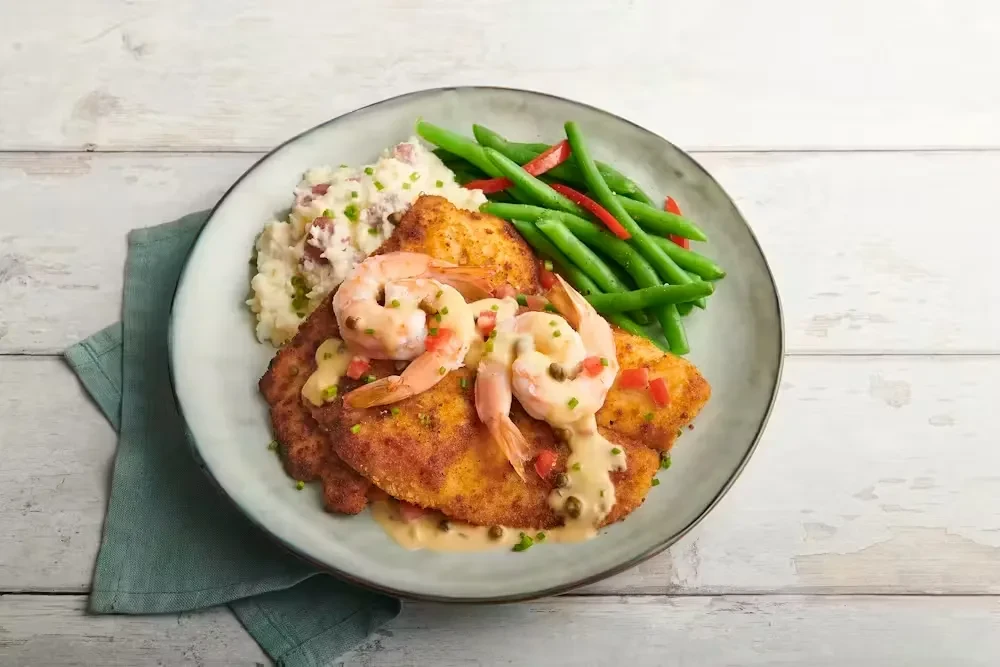 Overhead: plated pan-fried cutlets, shrimp, mashed potatoes, green beans.