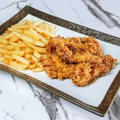 Crispy fried chicken and golden fries on a marble surface.