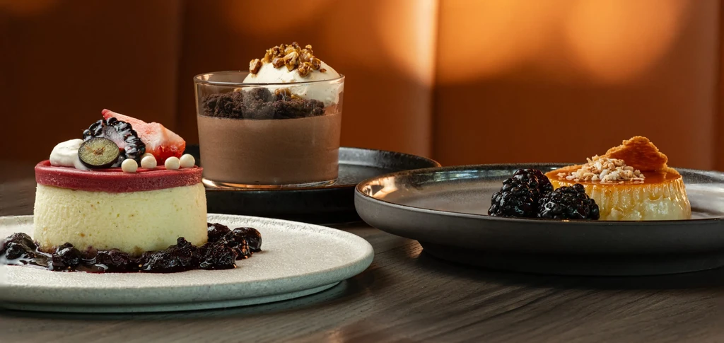 Three beautifully plated desserts: cheesecake, mousse, flan.