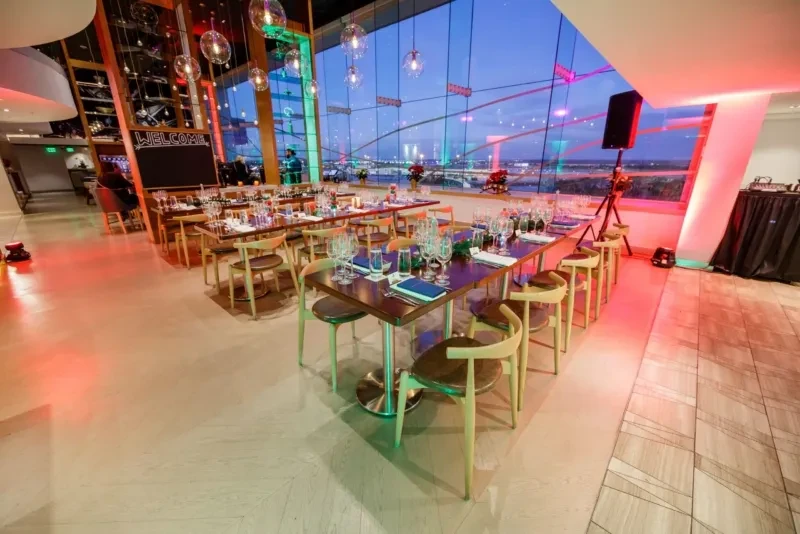 Upscale restaurant dining area with set tables and city view at night.