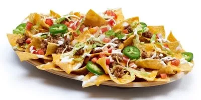 Nachos with beef, lettuce, tomatoes, jalapeños, and creamy white sauce.