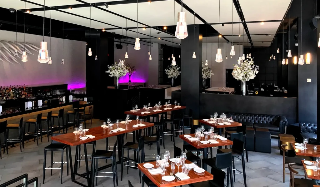 Modern, empty restaurant and bar with elegant black, white, wood decor.