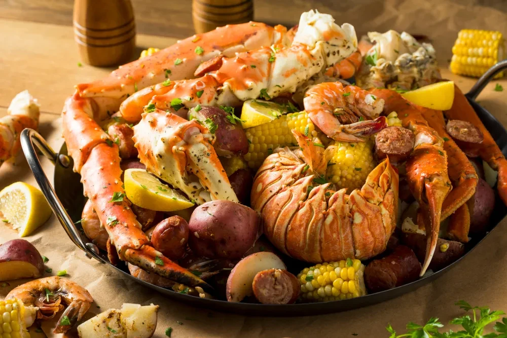 Seafood boil with king crab, lobster, shrimp, corn, potatoes, and sausage.