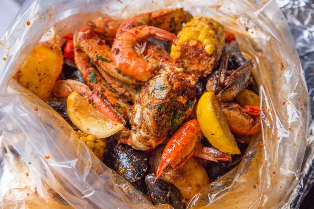 Colorful seafood boil with shrimp, crab, corn, lemon in a bag.