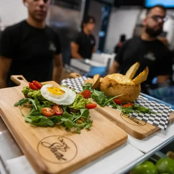 Avocado toast with egg, creamy bread bowl, on wooden boards.