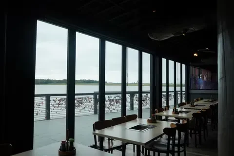 Restaurant interior with hot pot tables, large windows, water view, love locks.