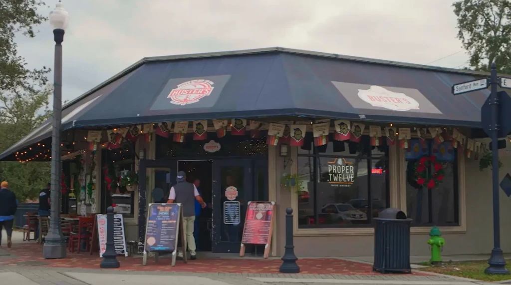 Buster's restaurant exterior on a decorated street corner with people.