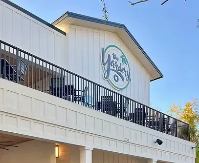 The Yardery building exterior: white siding, balcony, address 231.