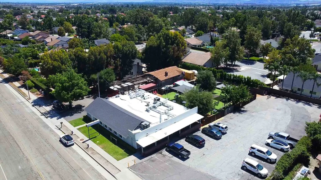 Drone photo of a restaurant with large parking lot and outdoor dining.