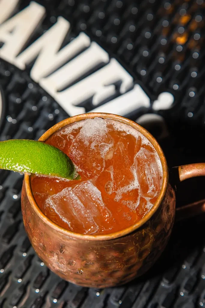 Moscow Mule in a hammered copper mug with ice and lime wedge.