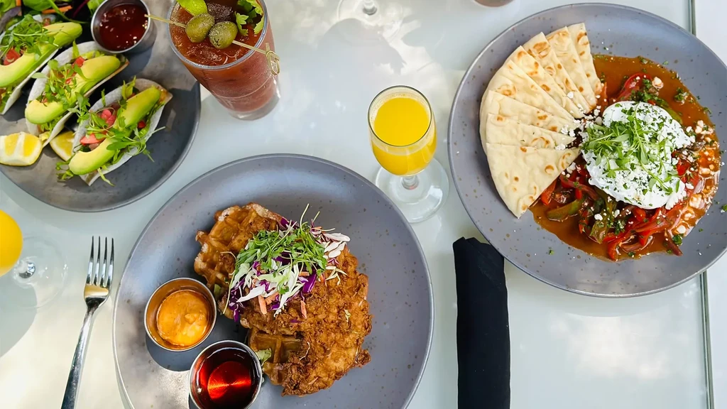 Overhead view of a table set with multiple colorful food and drink dishes.