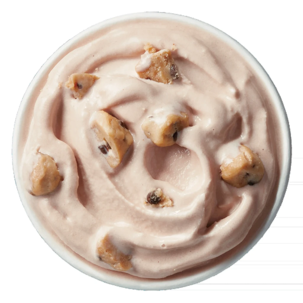 Swirled pinkish-brown ice cream with cookie dough in a white bowl.