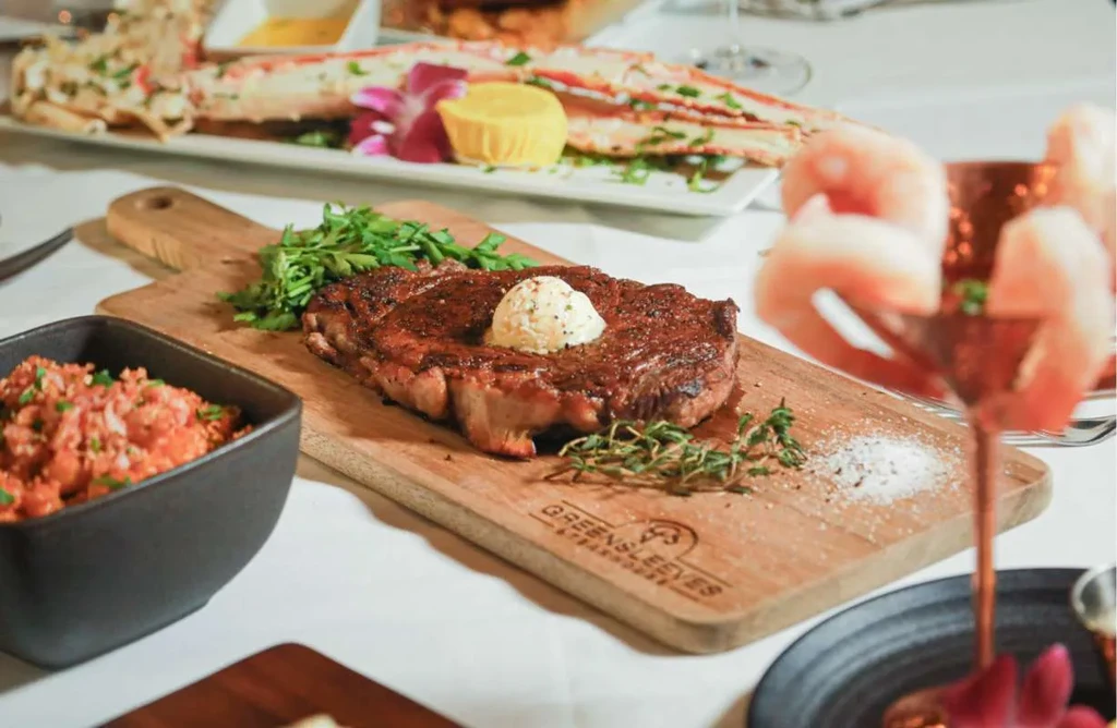 Greensleeves Steakhouse steak, crab legs, and shrimp on a lavish table.
