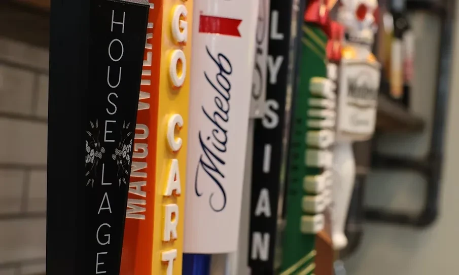 Close-up of various colorful beer tap handles: House Lager, Go-Cart, Michelob.