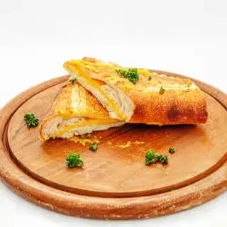 Toasted cheese sandwich halves with herbs on a wooden board.
