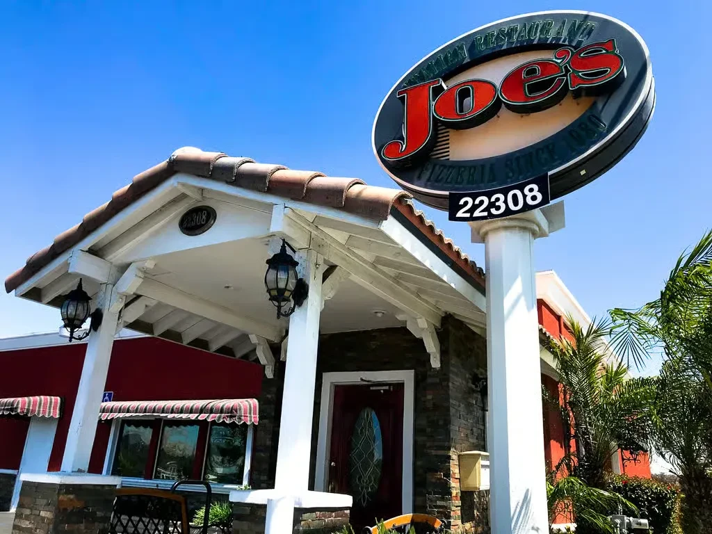 Exterior of Joe's Italian Restaurant Pizzeria, prominent sign, sunny day.