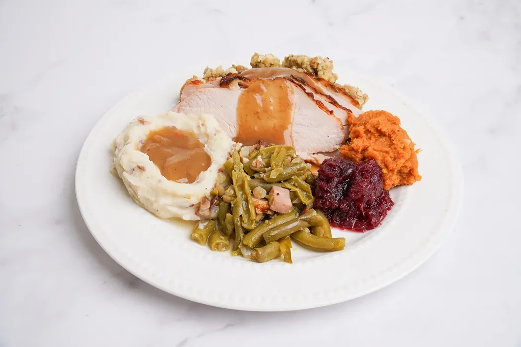 Hearty holiday plate: turkey, mashed potatoes, sweet potatoes, stuffing, green beans, cranberry.