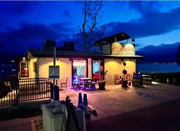 Joe's BBQ waterside restaurant at night, lit with outdoor seating.