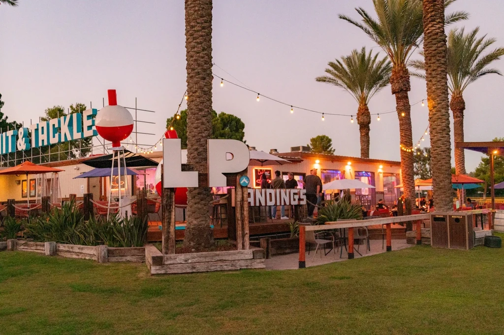 Outdoor restaurant "LP LANDINGS Bait & Tackle" at dusk with people.