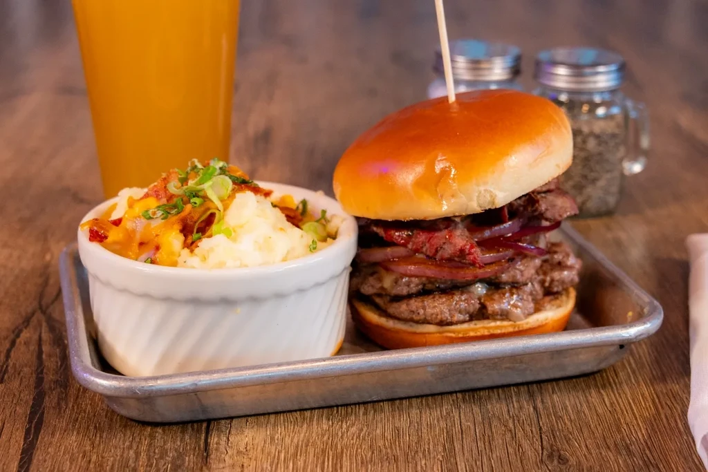 Multi-patty burger with onions and cheesy bacon mashed potatoes.