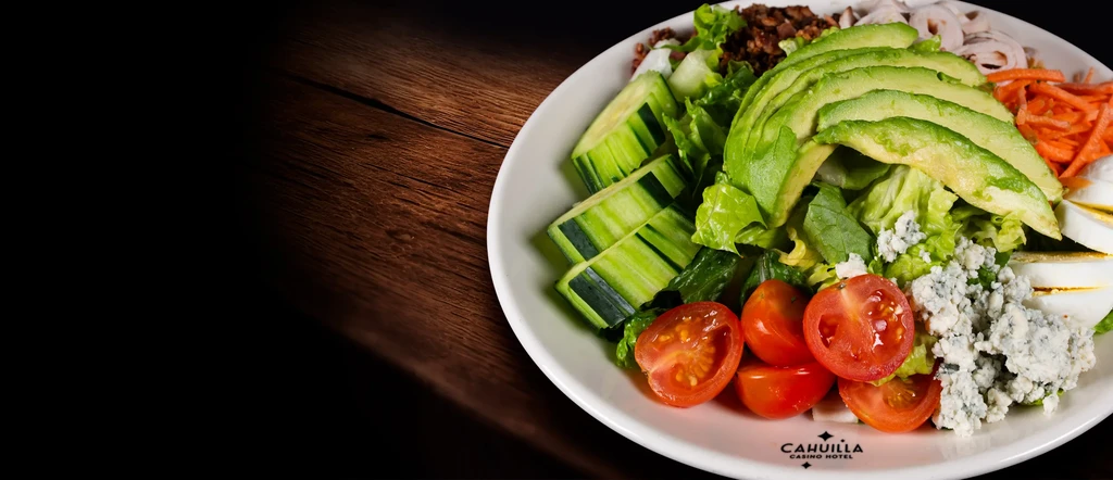 Colorful salad with avocado, lettuce, egg, and blue cheese.