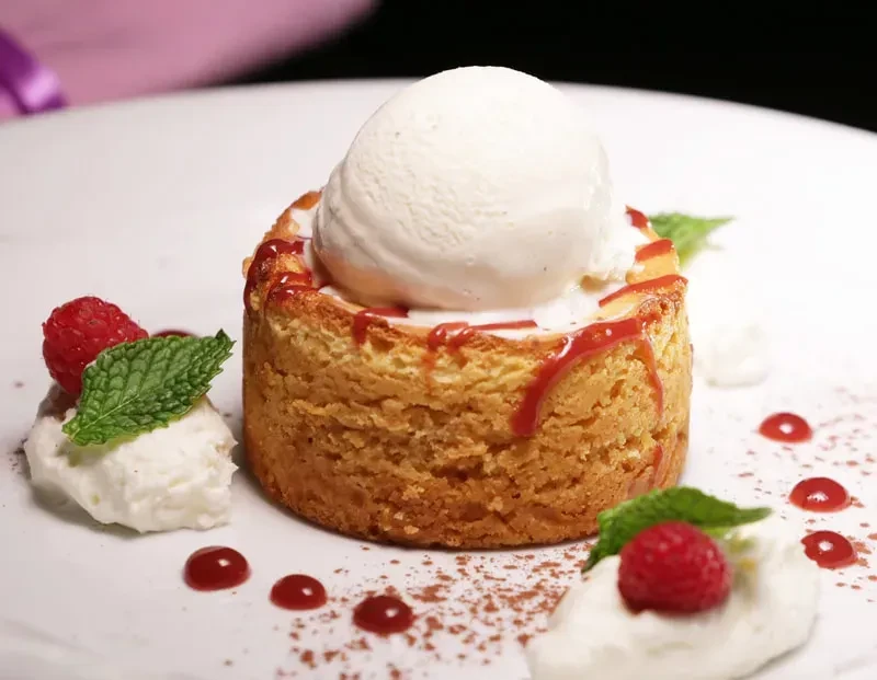 Golden cake, melting vanilla ice cream, red syrup, raspberries, and mint.