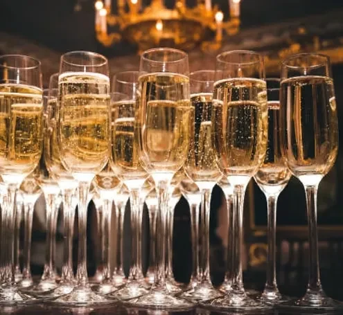 Numerous champagne flutes filled with sparkling golden drink.