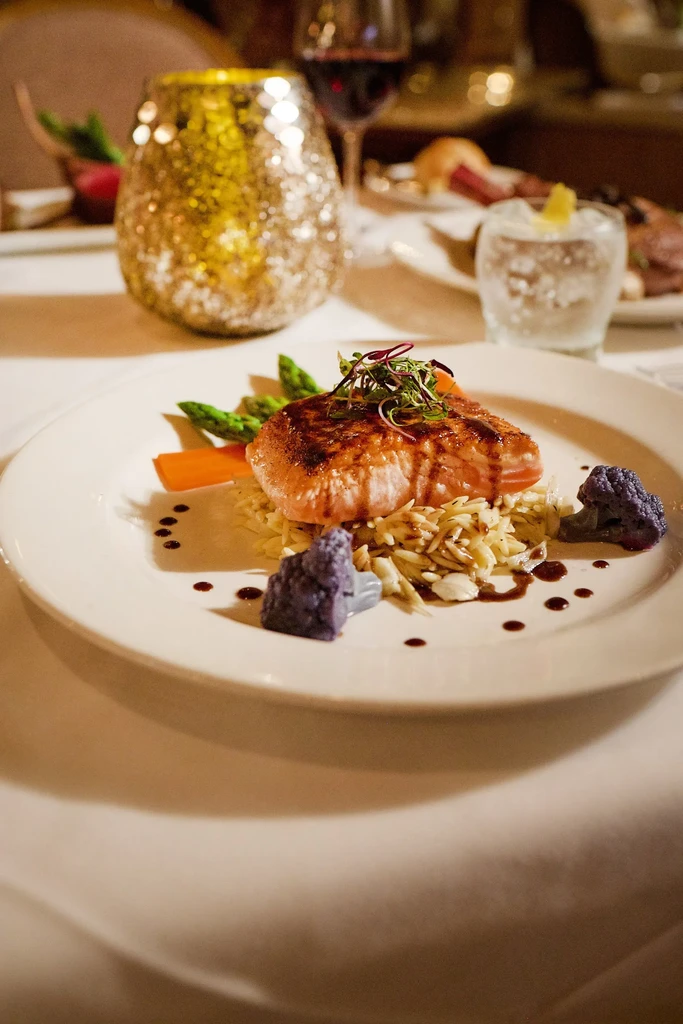 Seared salmon on orzo with asparagus, purple cauliflower, and sauce.