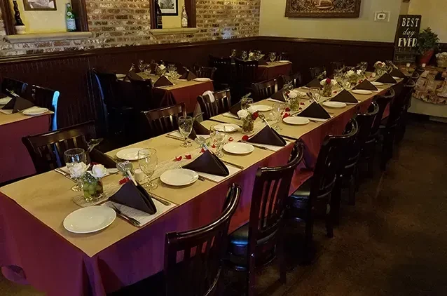 Cozy restaurant interior with a long dining table set for an event.