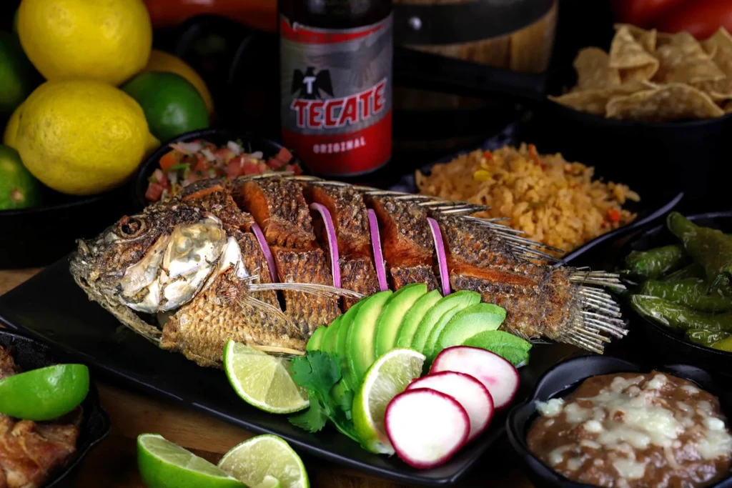 Fried fish meal with rice, beans, pico de gallo, and Tecate beer.