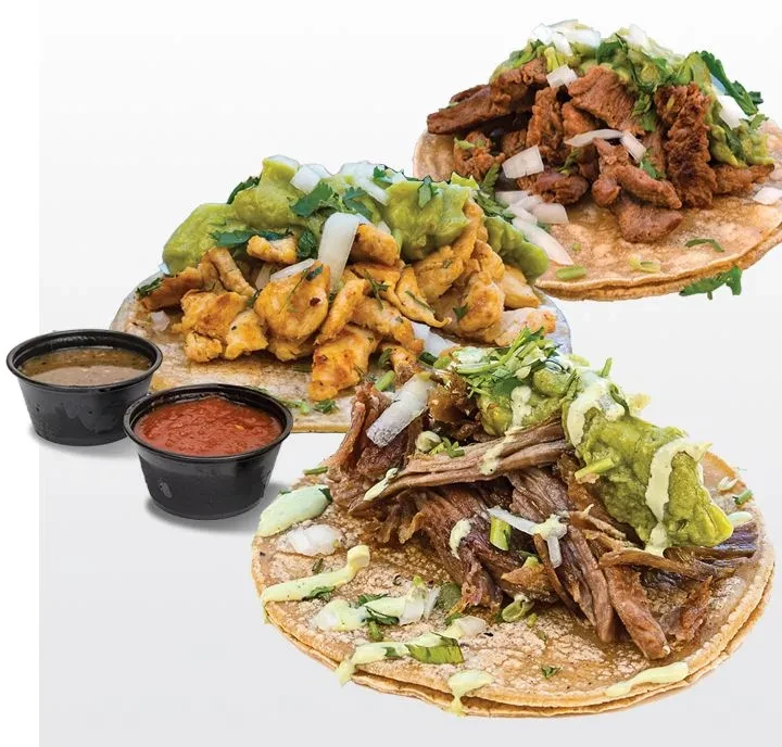 Three different fully loaded tacos with sauces on white background.
