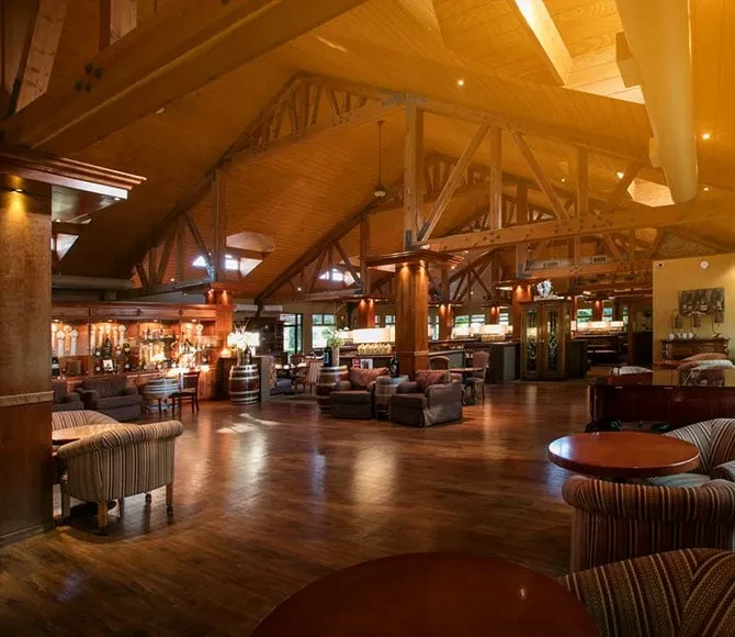 Spacious restaurant interior with high vaulted wooden ceiling and full bar.