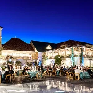 Large outdoor venue at twilight with many people dining.
