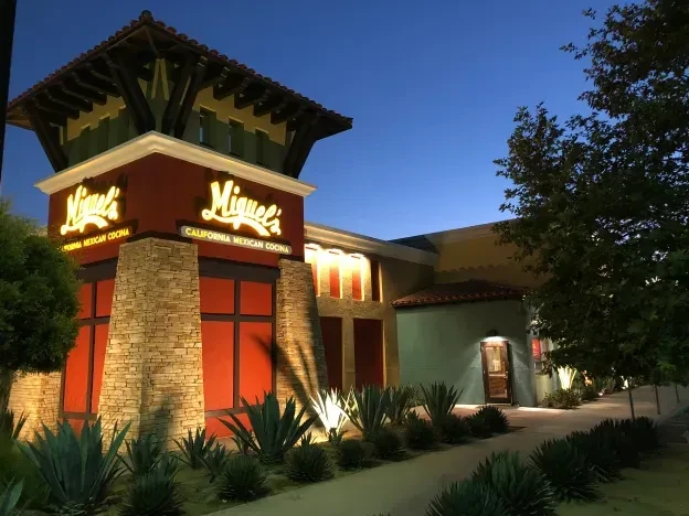Miguel's California Mexican Cocina: illuminated red-walled exterior at twilight.