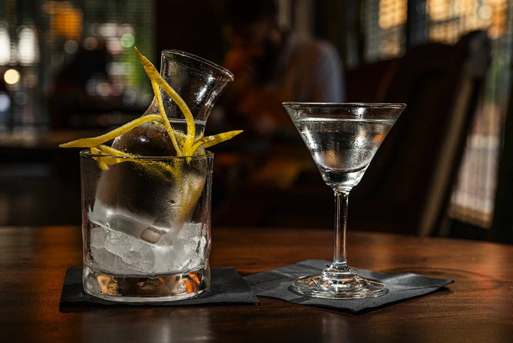 Two frosted cocktails, a rocks glass and a martini, on a table.