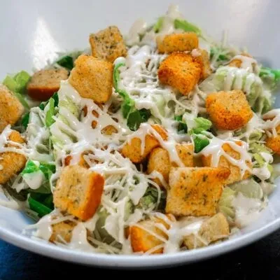 Top-down Caesar salad with romaine, croutons, Parmesan, and creamy dressing.