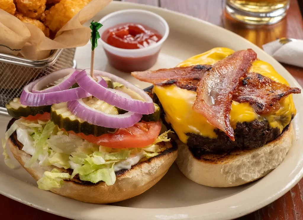 Classic open-faced cheeseburger with bacon, tater tots, and ketchup.