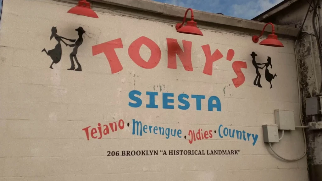 Exterior sign for TONY'S SIESTA featuring music genres and dancing silhouettes.